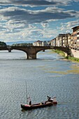 Italien, Toskana, Florenz, der Fluss Arno und ein traditionelles Boot unter der Vecchio-Brücke