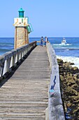 France, Landes, Capbreton, boom and lighthouse on the Atlantic coast with a fishing boat going off