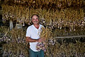 France, Tarn et Garonne, The Cause, portrait of Jean Luc Cayrel, producer of Ail Violet AOC, and world champion of the braid in 2012, after the harvest, garlic is stored in the barn for drying