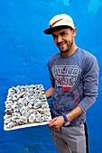 Morocco, Western Sahara, Dakhla, waiter of the restaurant Tal a mar with a tray of dhuitres in the arms