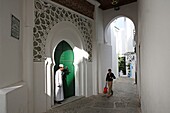 Marokko, Tanger Region Tetouan, Tanger, alte Tangerois in einem gewölbten Gang vor der Tür einer Moschee