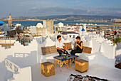 Marokko, Tanger Region Tetouan, Tanger, Hotel Dar Nour, Paar sitzt auf der weißen Terrasse des Gästehauses Dar Nour mit Blick auf die Kasbah