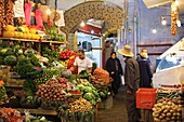 Marokko, Tanger Region Tetouan, Tanger, Marokkaner beim Einkaufen vor einem Obst- und Gemüsestand auf dem Souk