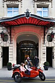 France, Paris, Royal Monceau hotel, woman riding in a retro side car in front of the hotel facade guarded by two valet