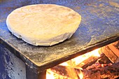 Portugal, Insel Madeira, Funchal, bolo do caco (traditionelles Brot aus Mehl und Süßkartoffeln) über einem Holzfeuer gebacken