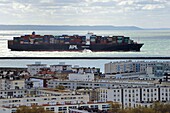 Frankreich, Seine Maritime, Le Havre, ein Containerschiff verlässt den Handelshafen und scheint den Gebäuden zu folgen