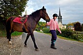 France, Calvados, Pays d'Auge, La Roque Baignard, young girl going out to ride