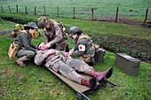 France, Eure, Sainte Colombe prés Vernon, Allied Reconstitution Group (US World War 2 and french Maquis historical reconstruction Association), reenactors in uniform of the 101st US Airborne Division and nurses caring for a wounded soldier