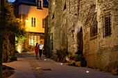France, Morbihan, Josselin, couple going down the street of Val d'Oust a summer evening