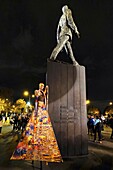 France, Paris, av. des Champs Elysees, African girl in a stylized dress on her stilts in front of General de Gaulle statue during the Nuit Blanche Constellation des Invalides
