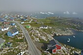 Greenland, West Coast, Disko Island, the village of Qeqertarsuaq and icebergs in the background (aerial view)