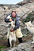 Greenland, West Coast, Uummannaq, the sled dog breeder Malti Suulutsun wearing bear skin trousers