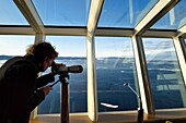 Grönland, Nordwestküste, Smith-Sund nördlich der Baffin Bay, Hurtigruten-Kreuzfahrtschiff MS Fram, Passagier beobachtet das arktische Meereis aus dem Panoramaraum