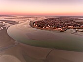 France, Somme, Baie de Somme, Le Crotoy, aerial view of the sunrise over the village of Crotoy and the slikke discovered by the low tide