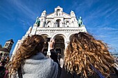 France, Paris, Montmartre, a young tourist photograph the Basilica of the Sacre Coeur