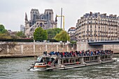 France, Paris, Notre Dame de Paris Cathedral, day after the fire, April 16, 2019, cruise ship passing in front of the cathedral
