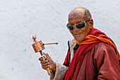 India, state of Jammu and Kashmir, Himalayas, Ladakh, Indus valley, monk turning prayer wheel in the courtyard of the gompa (monastery) of Hemis