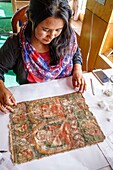 India, state of Jammu and Kashmir, Himalaya, Ladakh, valley of the Indus, Matho monastery (gompa), in the workshop of restoration a woman of the village of Matho takes care of reinforcing an extremely precious thangka of the beginning of XIIe century