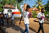 Sri Lanka, Central province, Kandy, a World Heritage Site, royal palace complex, pilgrims bringing offerings at the Temple of the Sacred Tooth Relic, St. Paul's Anglican Church in the background