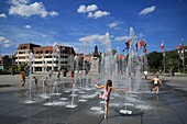 France, Haut Rhin, Colmar, children playing in the fountains of Place Rapp in Colmar