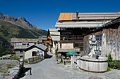 Frankreich, Hautes Alpes, Queyras-Massiv, Saint Veran, Straße und Holzbrunnen im Dorf
