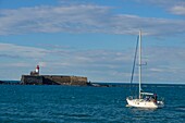 France, Herault, Agde, Cape of Agde, Fort of Brescou with a sailboat in the foreground