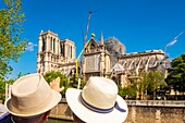 France, Paris, area listed as World heritage by UNESCO, Ile de la Cite, 2 tourists watch Notre Dame cathedral
