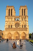 France, Paris, UNESCO World Heritage Site, Chinese newlyweds in photo session in front of the Notre-Dame de Paris cathedral