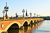 Frankreich, Gironde, Bordeaux, von der UNESCO zum Weltkulturerbe erklärtes Gebiet, die Pont de Pierre am Ufer der Garonne und die Basilika Saint Michel, die zwischen dem 14. und 16. Jahrhundert im gotischen Stil erbaut wurde und deren Turm 114 m hoch ist
