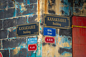 Blick auf Gebäude und Straßenschilder an der Wand in Chinatown, Port Louis, Mauritius, Indischer Ozean, Afrika