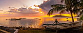 Blick auf einen Einheimischen, der auf einem Boot sitzt und Le Morne von Le Morne Brabant aus bei Sonnenuntergang betrachtet, Distrikt Savanne, Mauritius, Indischer Ozean, Afrika