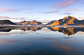 Berge und Rorbuer in einem Fjord bei Sonnenuntergang, Leknes, Vestvagoy, Nordland, Lofoten Inseln, Norwegen, Skandinavien, Europa
