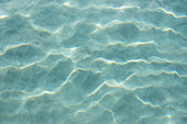 USA, Vereinigte Staaten von Amerika, Jungferninseln, St. John, Muster im Sand unter dem Licht, das sich auf der Wasseroberfläche spiegelt