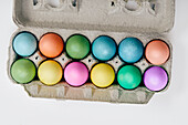 Overhead view of colorful Easter eggs in egg carton