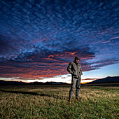 USA, Idaho, Bellevue, Farmer steht bei Sonnenaufgang auf einem Feld