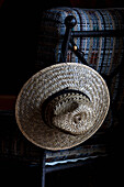 Straw hat hanging on chair