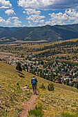 USA, Colorado, Creede, Rear view of woman hiking near town