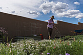 USA, New Mexico, Santa Fe, Frau bei der Gartenarbeit in der Hochwüste
