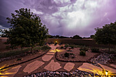 USA, New Mexico, Santa Fe, Storm clouds over garden in High Desert