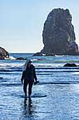USA, Oregon, Woman wading in ocean at Cannon Beach 