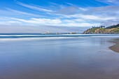 USA, Oregon, Seichtes Meerwasser am sandigen Cannon Beach