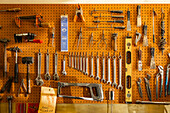 Werkzeuge an Haken an der Wand einer Holz- und Metallwerkstatt