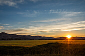 USA, Idaho, Bellevue, Sun setting behind foothills in rural landscape