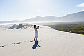 South Africa, Hermanus, Teenage girl (16-17) exploring and photographing Walker Bay Nature Reserve
