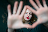 Porträt eines Mädchens im Teenageralter (16-17), das einen Fingerrahmen macht