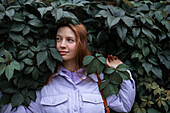 Porträt einer Frau in lila Jacke vor einem Baum