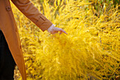 Woman in trench coat touching crop 