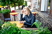 Thoughtful woman drinking coffee in sidewalk cafe
