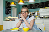 Porträt einer ernsten Frau, die in einem Café sitzt