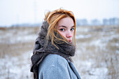 Porträt einer jungen Frau, die in einer verschneiten Landschaft steht